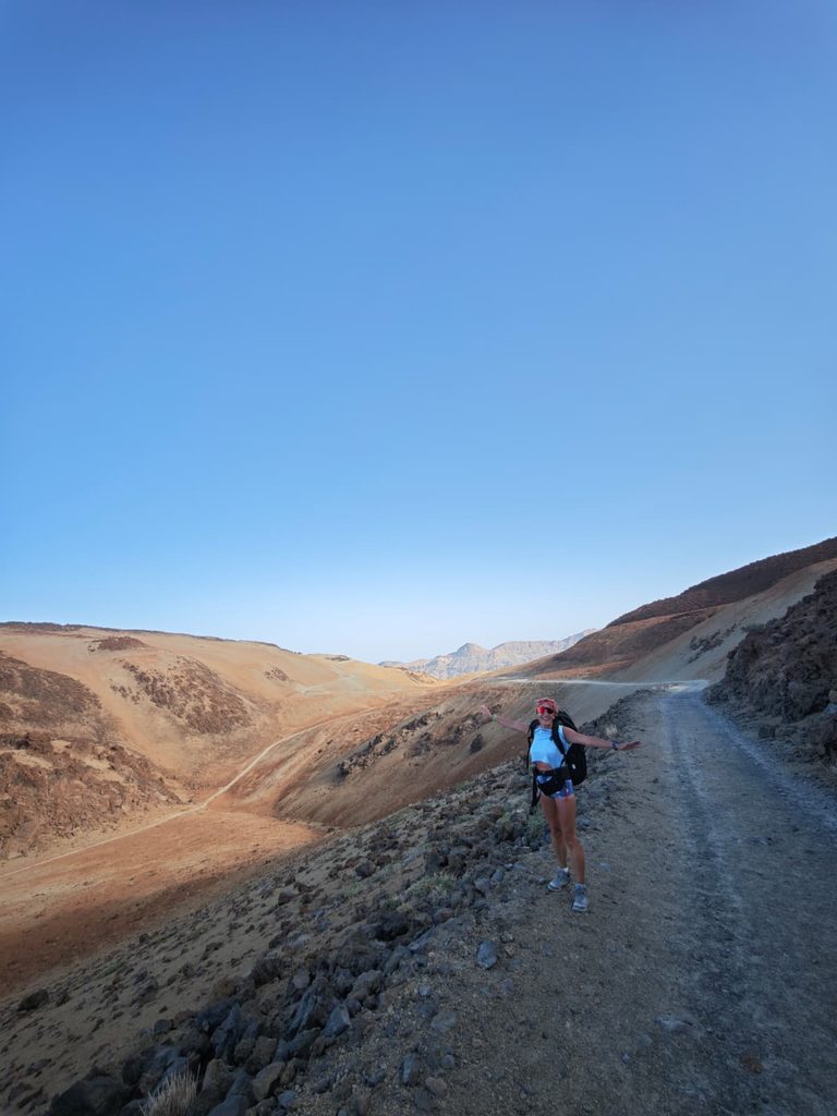 Hiker on the wide gravel track of trail 7 through the pumice landscape of Montaña Blanca, Tenerife
