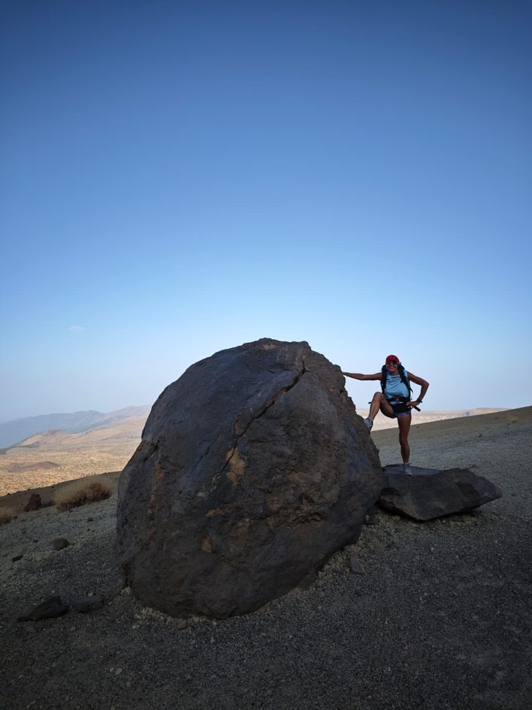 A Huevo del Teide, a huge black ball of solid lava beside the trail up Teide, with a hiker standing next to it